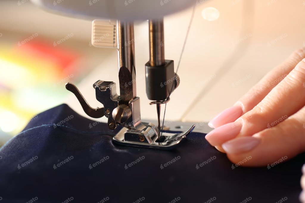 Close-up of a sewing machine needle stitching navy fabric